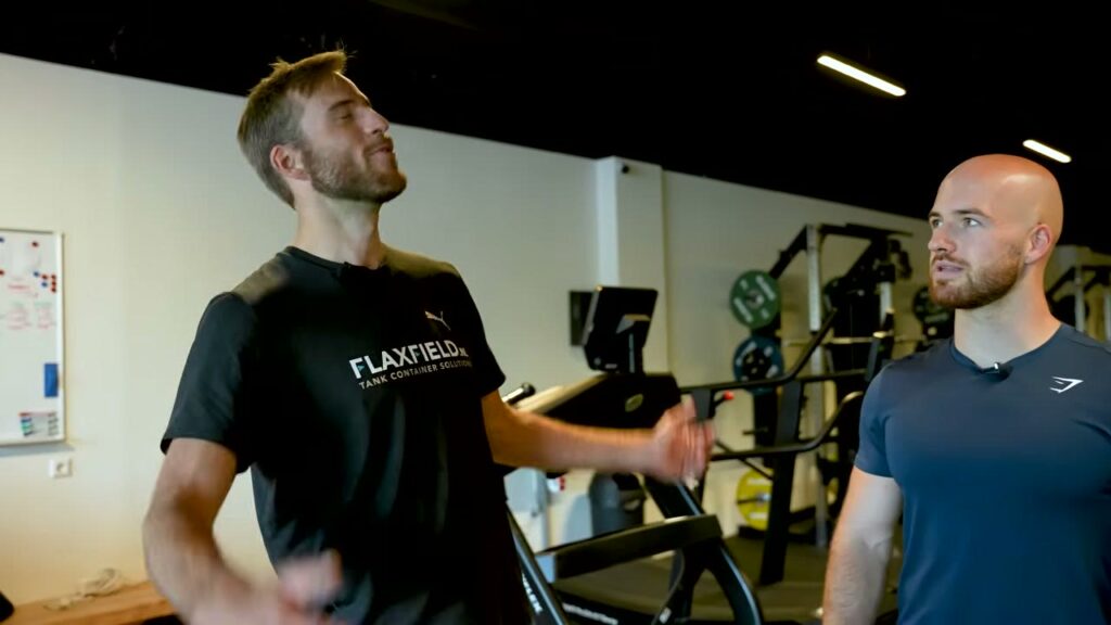 Twee sporters in gesprek in de gym naast de loopband